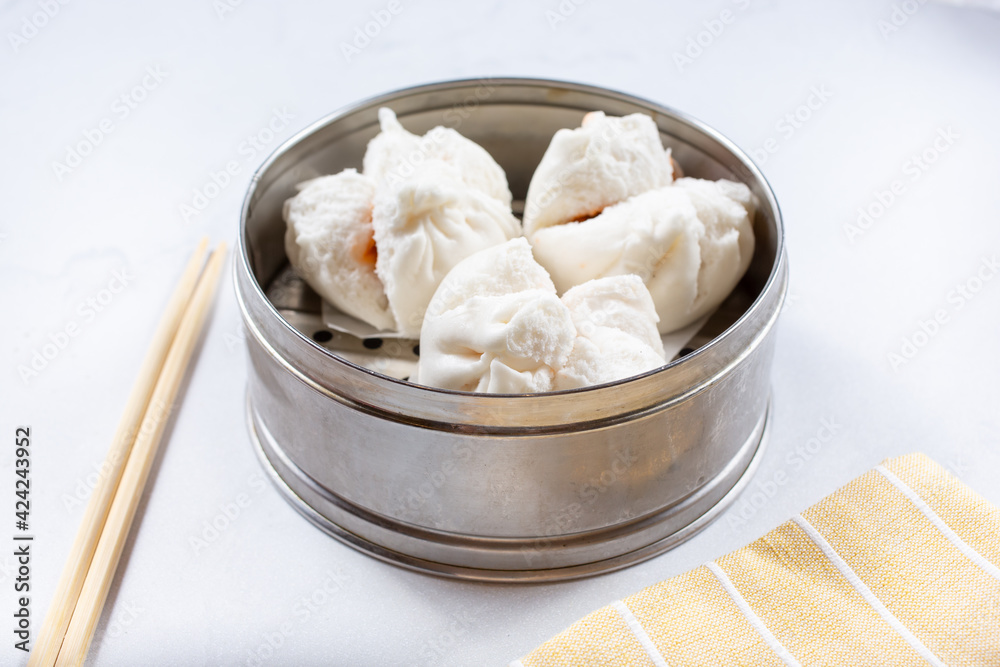 A view of a steamer container featuring BBQ pork buns. A view of a steamer container featuring BBQ pork buns.