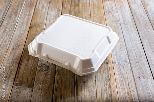A view of a food styrofoam container on a table. photo