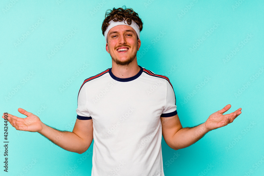 Young sport caucasian man isolated on blue background showing a welcome expression. Young sport caucasian man isolated on blue background showing a welcome expression.