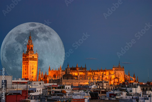 A full moon behind the illuminated cathedral in Seville, Spain © Rob