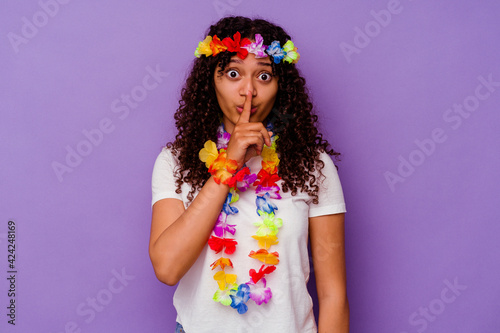 Young Hawaiian woman isolated on purple background keeping a secret or asking for silence.