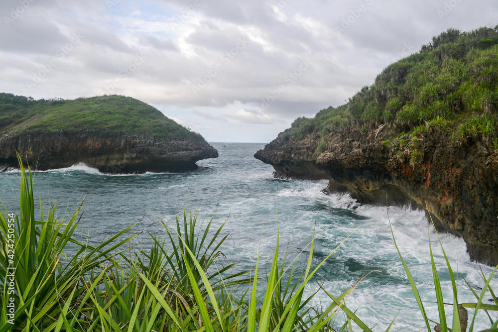 Big waves and cliffs in Greweng Beach, Gunung Kidul Regency, Yogyakarta, Indonesia. Big waves and cliffs in Greweng Beach, Gunung Kidul Regency, Yogyakarta, Indonesia.