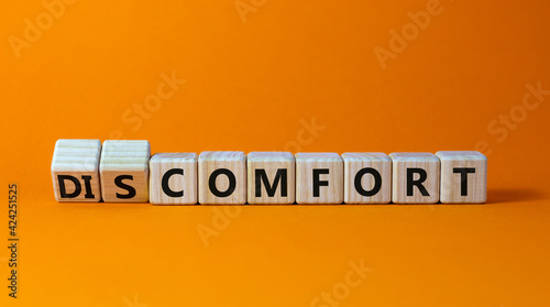 From discomfort to comfort symbol. Turned cubes and changed the word 'discomfort' to 'comfort'. Beautiful orange background, copy space. Business and from discomfort to comfort concept.