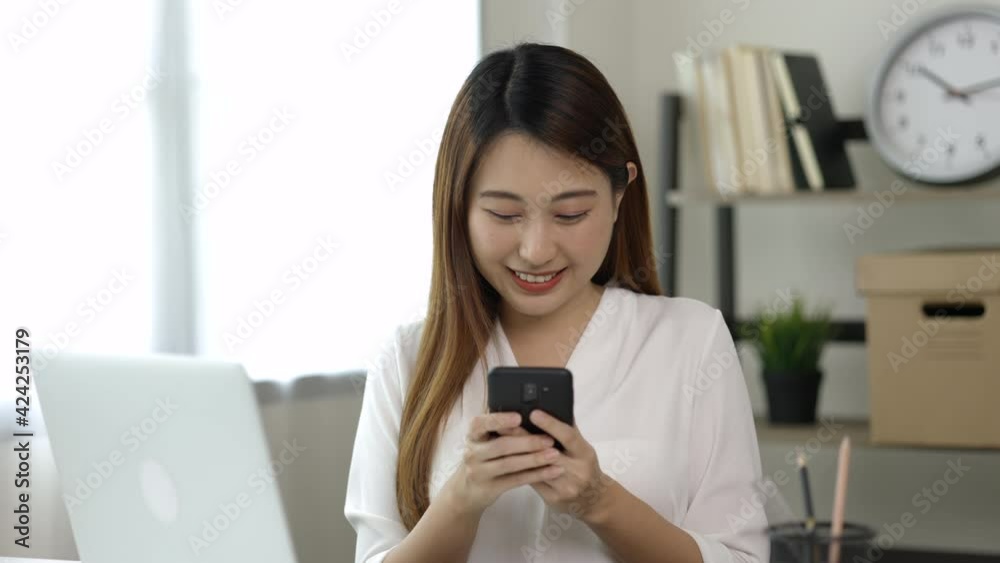 Young asian beautiful business woman using smartphone. Smiling charming happy young female texting touching on display of cell phone. Young asian beautiful business woman using smartphone. Smiling charming happy young female texting touching on display of cell phone.