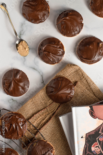 Tagalong cookies, copycat from girl scout's cookies. Made with chocolate and peanut butter on a shortbread cookie. White marble background photo