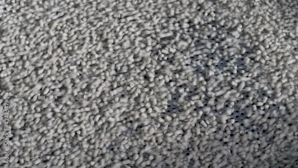 Plastic pellets jump on the grid of the vibrating table. Production of granular polyethylene. Plastic pellets jump on the grid of the vibrating table. Production of granular polyethylene.