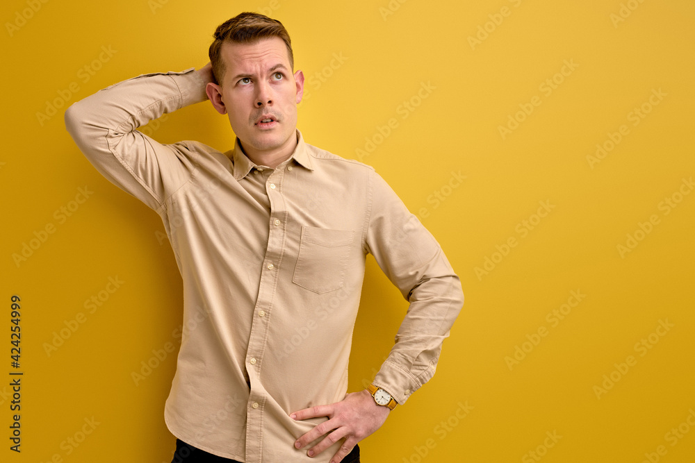 let s me think. man doubts his decision, isolated over yellow background let s me think. man doubts his decision, isolated over yellow background
