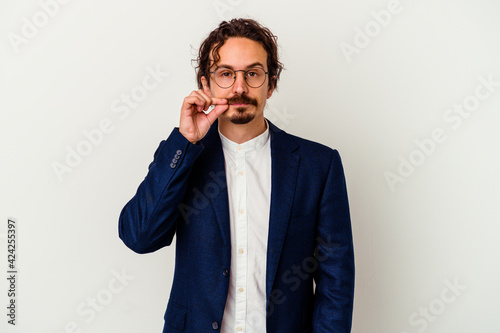 Young business man isolated on white background with fingers on lips keeping a secret.