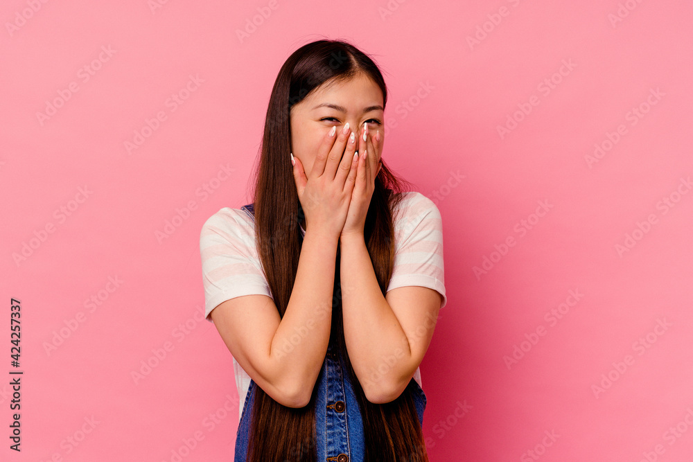 Young chinese woman isolated on pink background laughing about something, covering mouth with hands. Young chinese woman isolated on pink background laughing about something, covering mouth with hands.