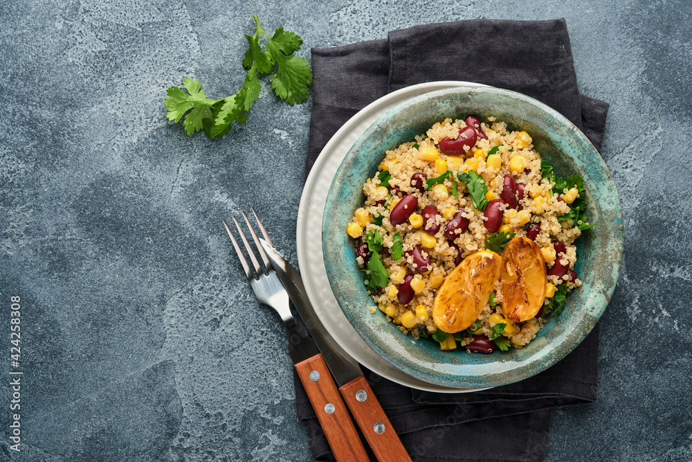 Mexican black bean corn quinoa salad with caramelized lemon in old vintage clay bowl on a dark gray concrete background. Traditional Mexican cuisine dish. Top view, mock up. Mexican black bean corn quinoa salad with caramelized lemon in old vintage clay bowl on a dark gray concrete background. Traditional Mexican cuisine dish. Top view, mock up.