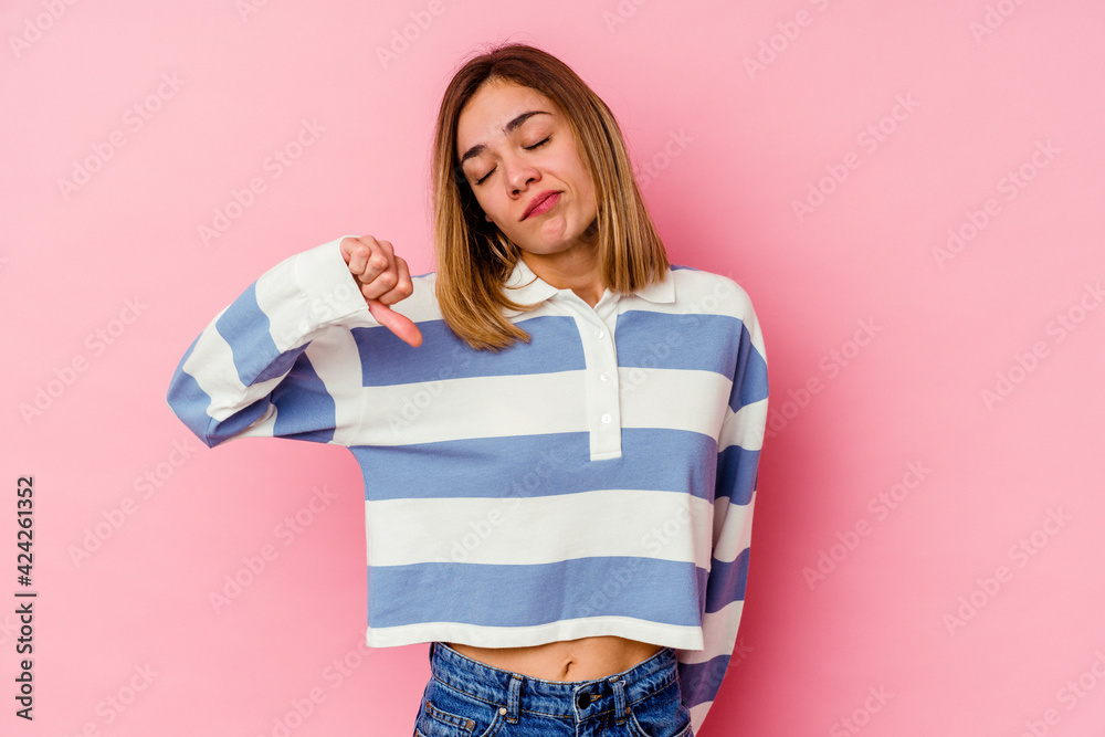 Young caucasian woman isolated on pink background showing a dislike gesture, thumbs down. Disagreement concept. Young caucasian woman isolated on pink background showing a dislike gesture, thumbs down. Disagreement concept.