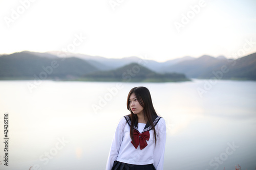 Asian school girl looking mountain with river in sunrise