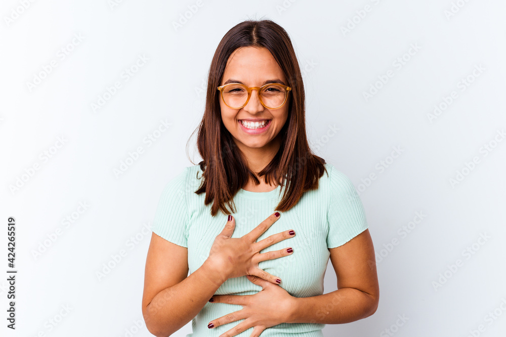 Obraz premium Young mixed race woman isolated laughs happily and has fun keeping hands on stomach.