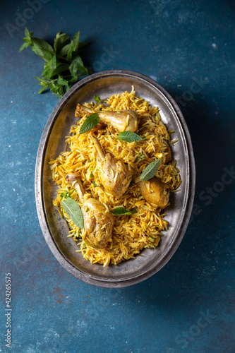 Indian or Pakistani food. Chiken Biryani rice biriany with mint herb and naan bread on blue background photo