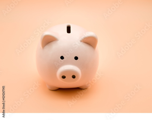 Pink piggy bank on a beige background. Money and business.