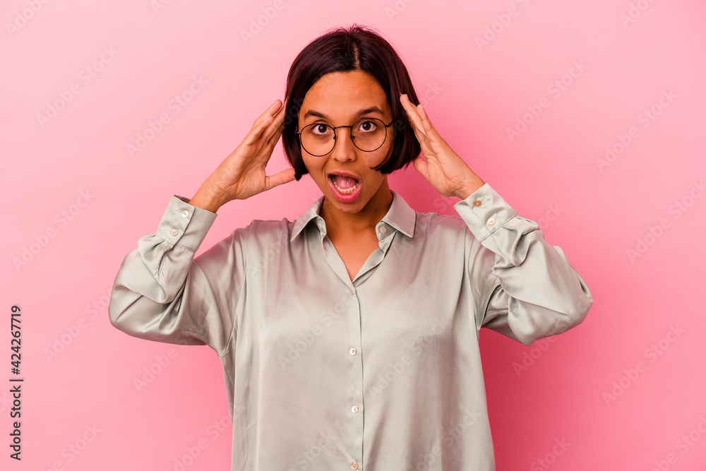 Young mixed race woman isolated on pink background celebrating a victory or success, he is surprised and shocked. Young mixed race woman isolated on pink background celebrating a victory or success, he is surprised and shocked.
