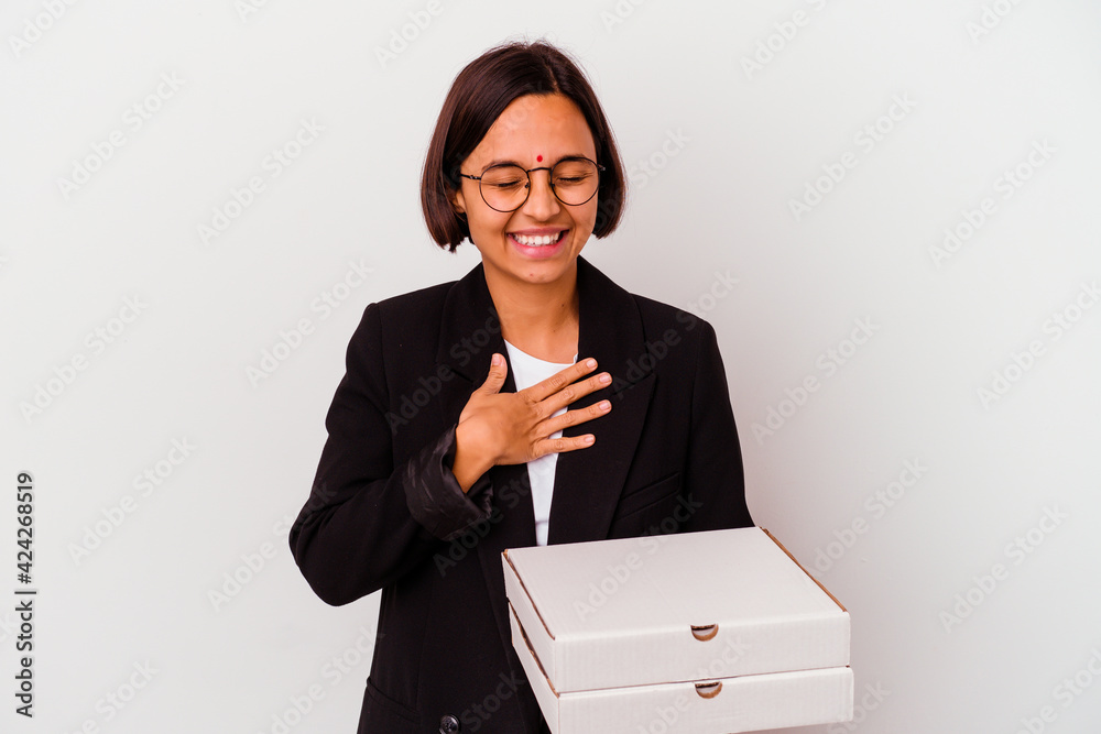 Young business indian woman holding pizzas isolated laughs out loudly keeping hand on chest. Young business indian woman holding pizzas isolated laughs out loudly keeping hand on chest.