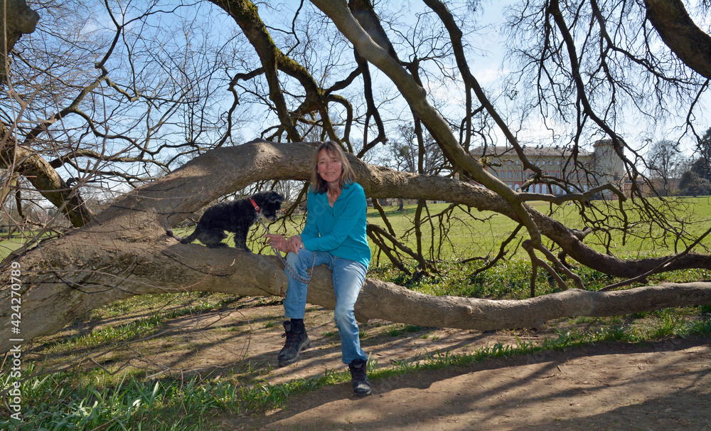 Naklejka premium frau mit hund im schlosspark worms-herrnsheim