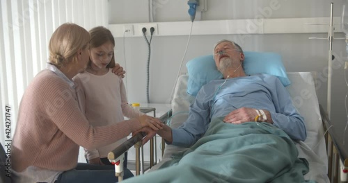 Upset grandmother and granddaughter visiting dying patient in hospital. photo