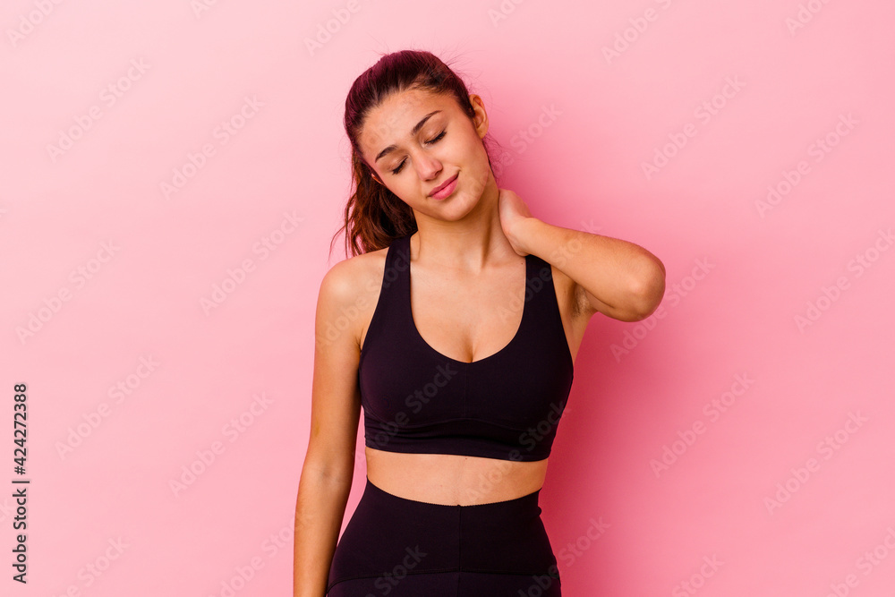 Young sport Indian woman isolated on pink background suffering neck pain due to sedentary lifestyle. Young sport Indian woman isolated on pink background suffering neck pain due to sedentary lifestyle.