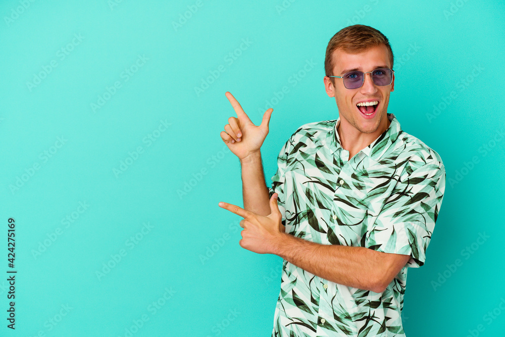 Young caucasian man wearing a summer clothes isolated on blue background Young caucasian man wearing a summer clothes isolated on blue background