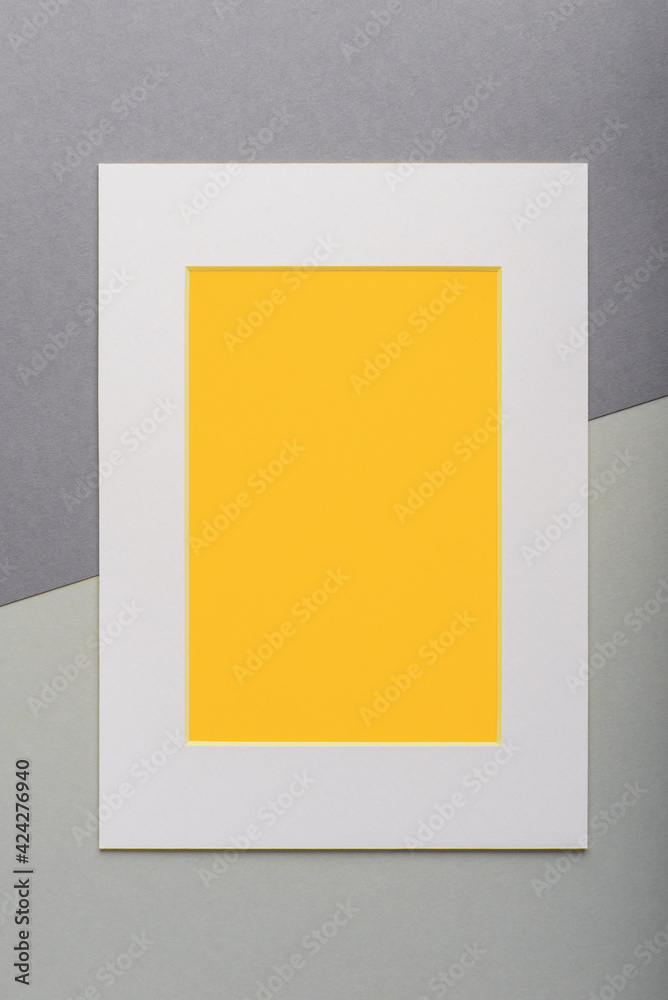 Yellow blank card in white frame over grey background Yellow blank card in white frame over grey background