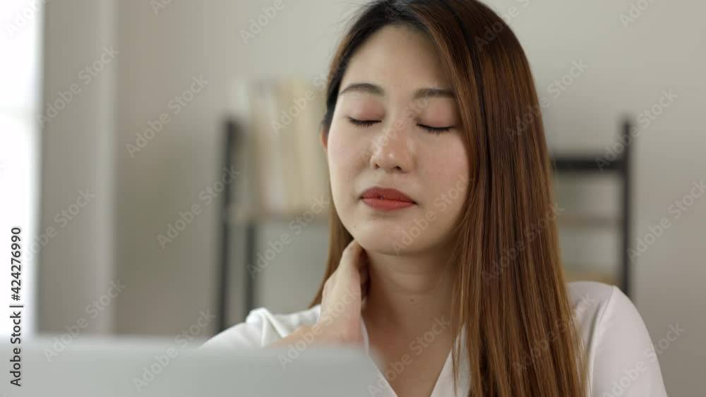 Young asian business woman rubbing her shoulder she's has shoulder, neck pain and hurt get stressed be tired from working with laptop a long time she symptom office syndrome. Young asian business woman rubbing her shoulder she's has shoulder, neck pain and hurt get stressed be tired from working with laptop a long time she symptom office syndrome.