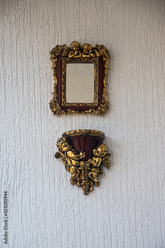 Golden and red frame to decorate a white wall in a house
