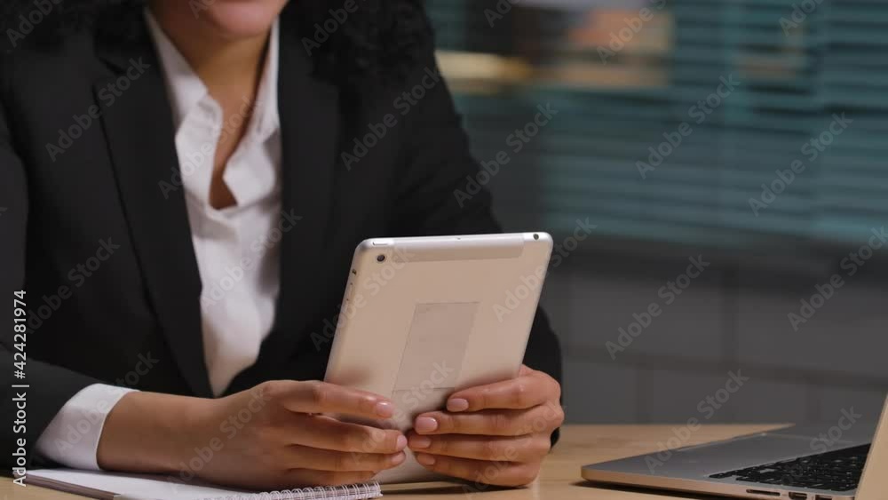 Portrait of African American talks on video call using digital tablet. Businesswoman posing at workplace, sitting at table in interior of office. Close up. Slow motion ready 59.94fps. Portrait of African American talks on video call using digital tablet. Businesswoman posing at workplace, sitting at table in interior of office. Close up. Slow motion ready 59.94fps.