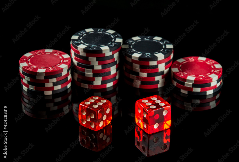 Dice with a maximum winning combination of twelve in poker on a black table and chips in the background Dice with a maximum winning combination of twelve in poker on a black table and chips in the background