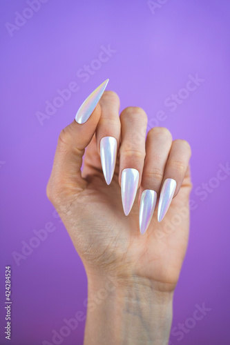 Pearlescent unicorn design manicure press-on nails isolated against a purple background
