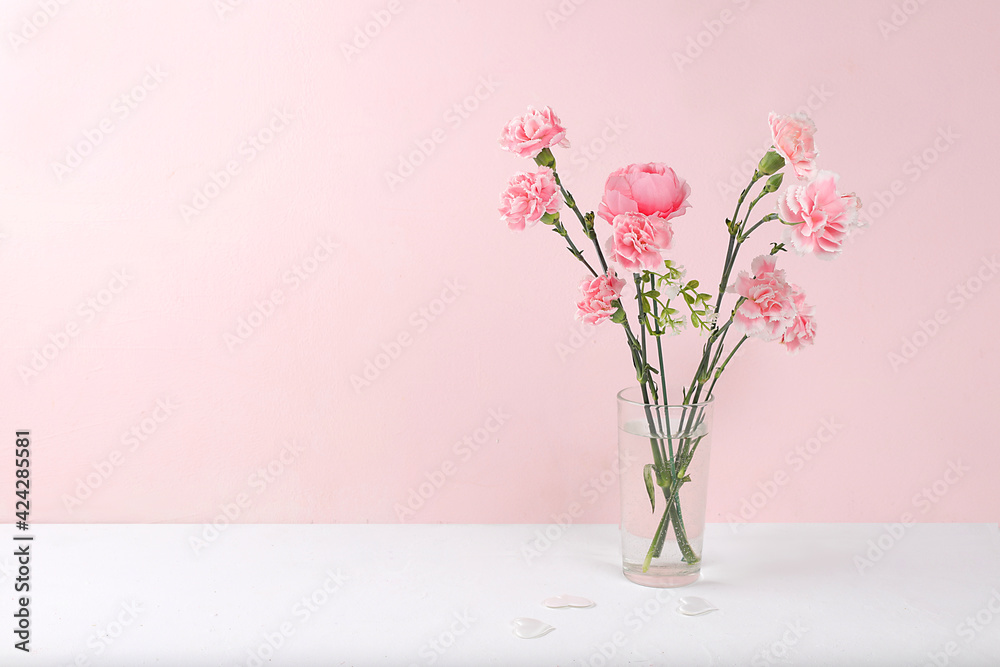 Carnations in a pink box, abstract spring floral background. Creative modern bouquet, minimal holiday concept. Postcard for womens day or mothers day, happy birthday, wedding, banner for the screen,