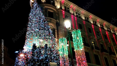 Still shot of a beautiful classic big building in Madrid , Spain. Used to be the bank of Spain and now a Hotel. it's heavily decorated with coloured Christmas lights hanging on the corner. Night. photo
