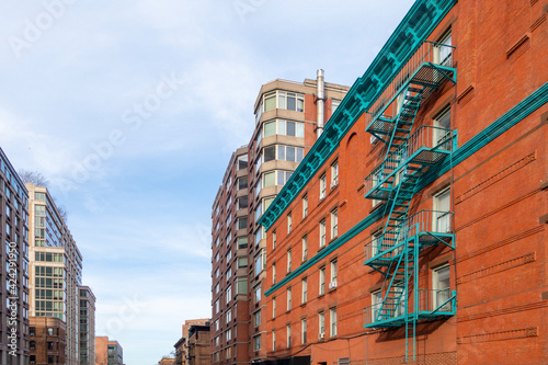 Manhattan new york city row of building brick fire escapes and day sky