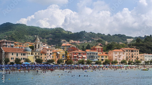 VILLAGE ON THE HILL OVERLOOKING THE SEA WHILE PEOPLE PLAY AND SWIM