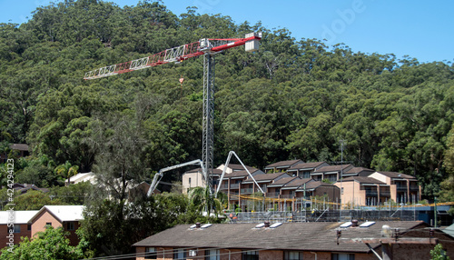 Concrete Boom Pump delivering material to new building site with bushland backdrop. Gosford, Australia. February 26, 2021. 56-58 Beane St. Part of a series.