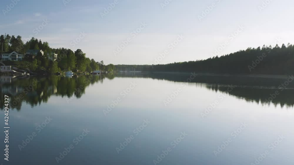 Flying over large reflective lake in beautiful Swedish landscape on summer day. Flying over large reflective lake in beautiful Swedish landscape on summer day.