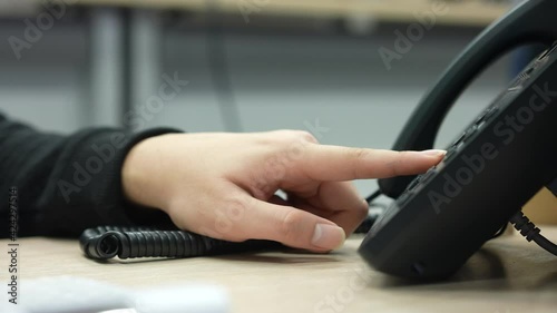 close up employee man hand press number on telephone for contact with someone , technology concept