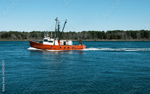 An old red and white fishing trawler passing through Cape Cod Canal