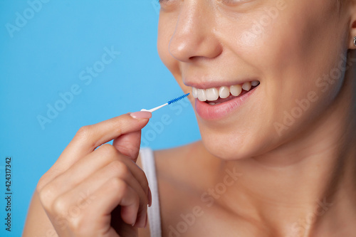 Woman uses brushes to clean the interdental spaces