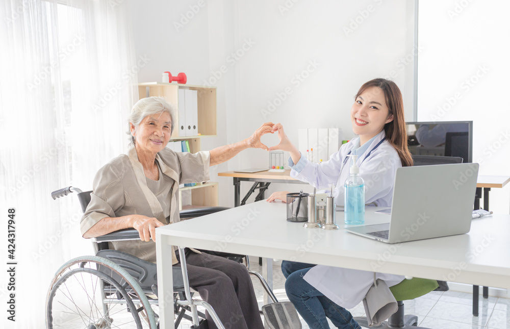 Obraz premium asian female doctor and old patient show heart sign with hands together, happiness and relationship in hospital, they feeling happy and smile, happiness hospital