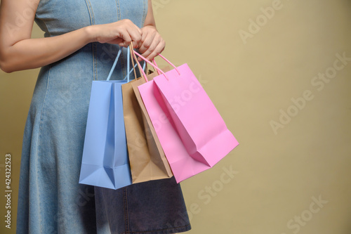 Young happy summer shopping woman with shopping bags isolated on grey background