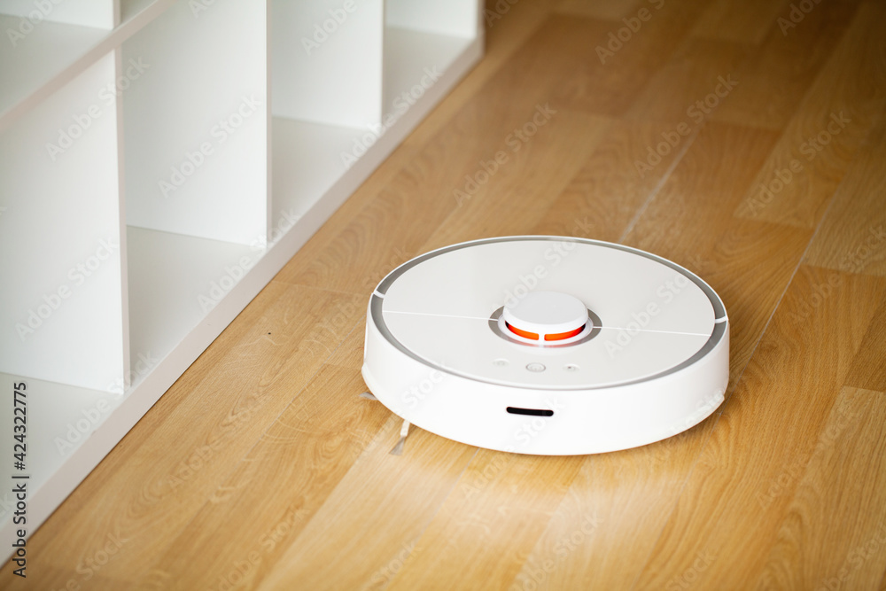 Vacuum cleaner robot runs on wood floor in a office Vacuum cleaner robot runs on wood floor in a office