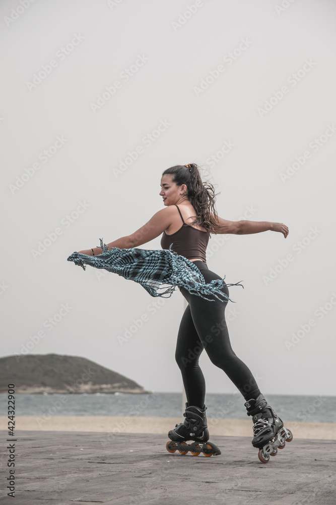 Naklejka premium Mujer patinando en paseo marítimo