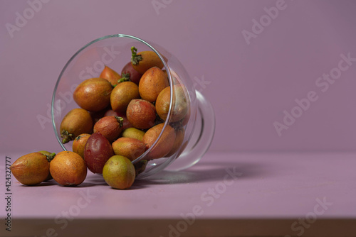 Caferana fruits (Bunchosia armeniaca) in natura served in a bowl on a pink background. photo