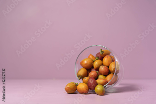 Caferana fruits (Bunchosia armeniaca) in natura served in a bowl on a pink background. photo