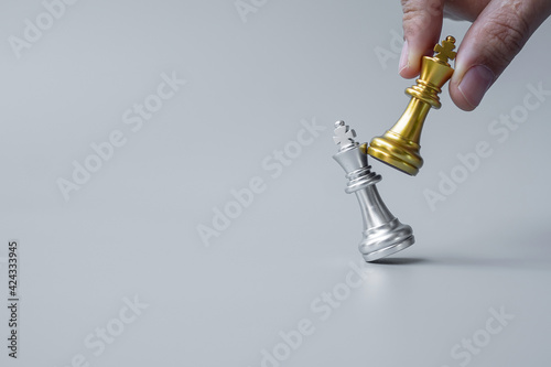 Fotografia businessman hand moving gold Chess King figure and Checkmate opponent during chessboard competition