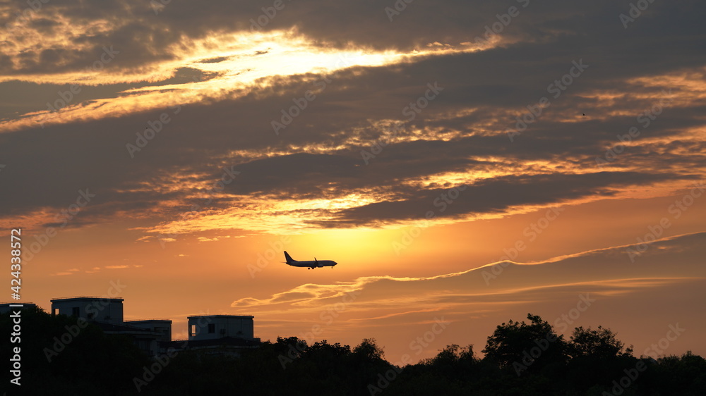 One airplane flying through the beautiful sunset sky One airplane flying through the beautiful sunset sky