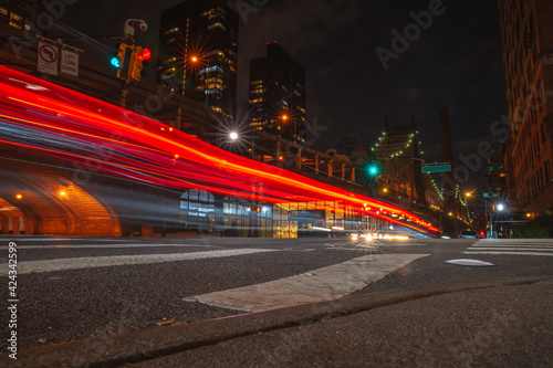 Long exposure motion shot. Night streets of New York city. Red light glowing traces