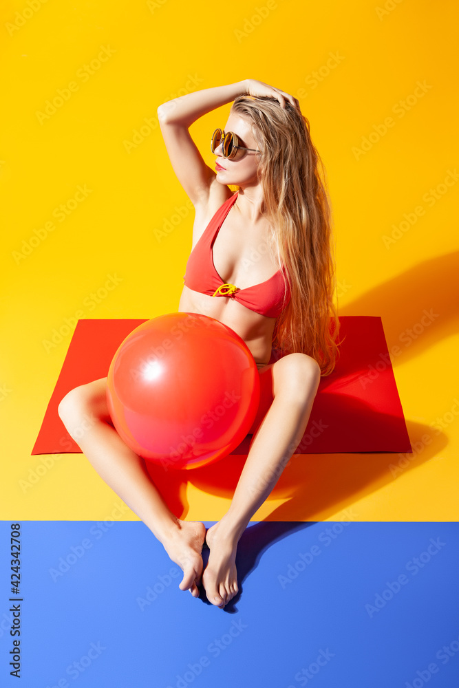 Woman in bikini with inflatable ball in studio Woman in bikini with inflatable ball in studio
